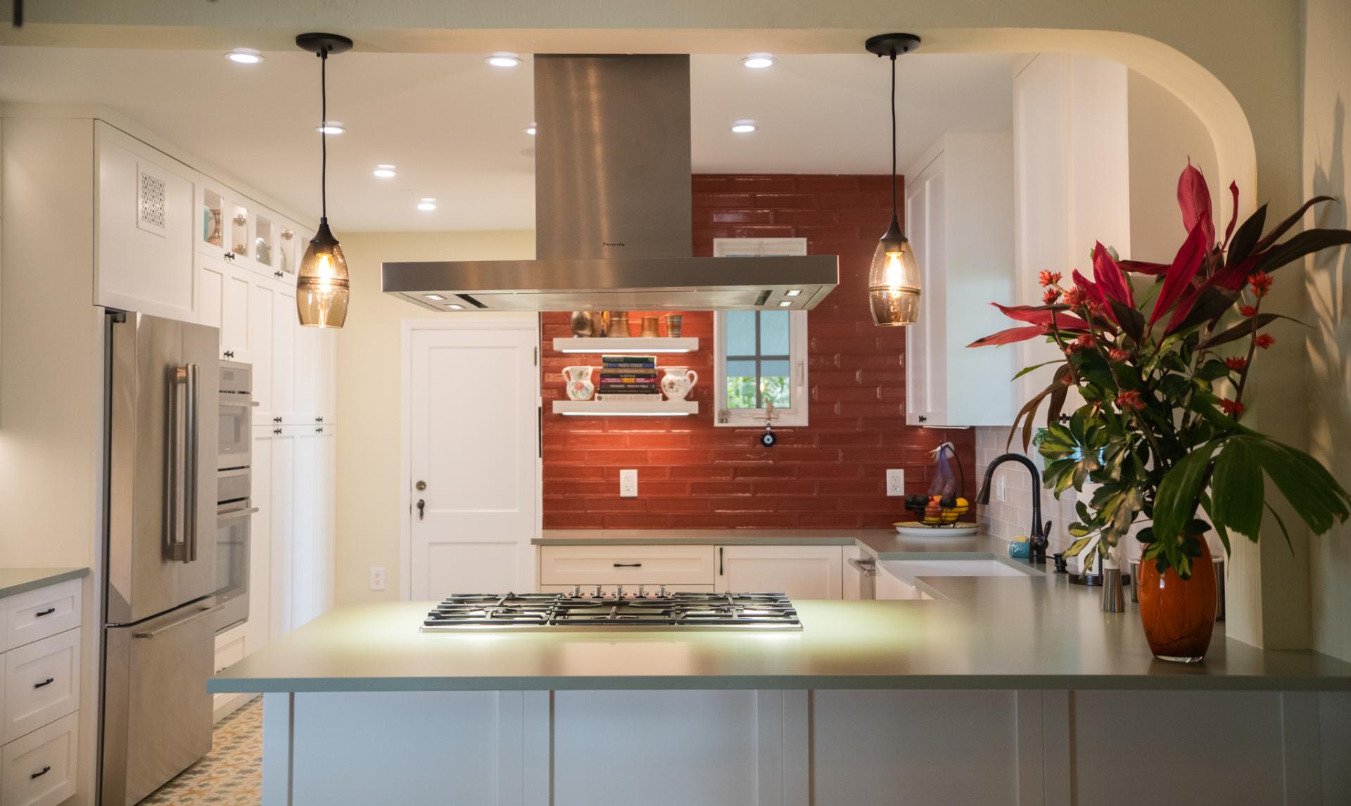 Warm custom kitchen with white cabinetry and a terracotta backsplash